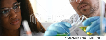 A male chemist holds test tube of glass A male chemist holds test tube of glass 60063015
