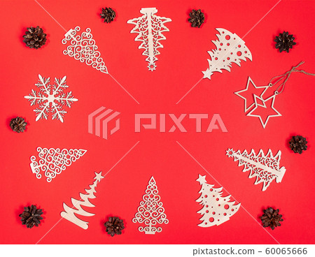 Festive christmas mockup over red background with copy space for text in center and xmas wooden decorations: Christmas trees, stars, snowflake, pine cones around it. Flat lay, top view. Festive christmas mockup over red background with copy space for text in center and xmas wooden decorations: Christmas trees, stars, snowflake, pine cones around it. Flat lay, top view. 60065666