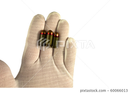 Hand in white glove holds three bullet on finger 60066013