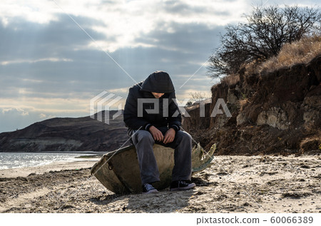 man is sitting aboard a broken boat man is sitting aboard a broken boat 60066389