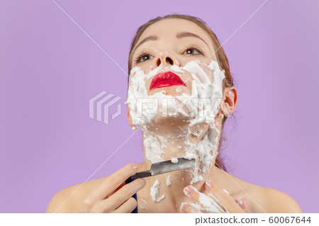 woman shaves her face woman shaves her face 60067644