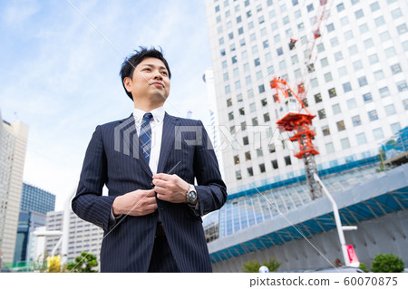 Businessman standing in front of construction site Businessman standing in front of construction site 60070875