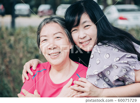 asian senior mother and her adult daughter are 60075729