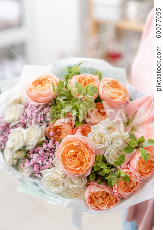 European floral shop. Beautiful bouquet of mixed flowers in womans hands. the work of the florist at European floral shop. Beautiful bouquet of mixed flowers in womans hands. the work of the florist at 60077095