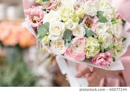 European floral shop. Beautiful bouquet of mixed flowers in womans hands. the work of the florist at 60077244