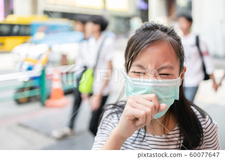Asian child girl suffer from cough with face mask protection,sick female teen wearing medical mask because of air pollution in the city street,dust flies in the air,concept of pollution,dust allergies Asian child girl suffer from cough with face mask protection,sick female teen wearing medical mask because of air pollution in the city street,dust flies in the air,concept of pollution,dust allergies 60077647