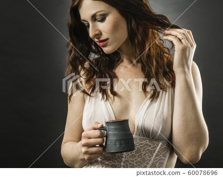 Beautiful smiling redhead woman drinking coffee Beautiful smiling redhead woman drinking coffee 60078696