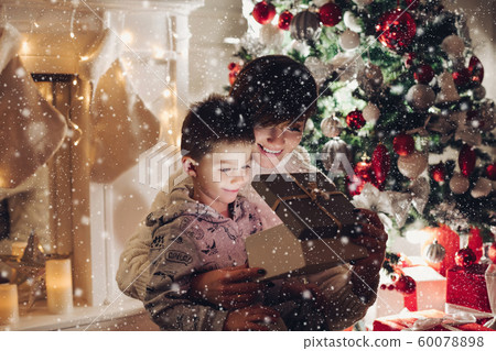 Mom and son in open a Christmas present in a box 60078898