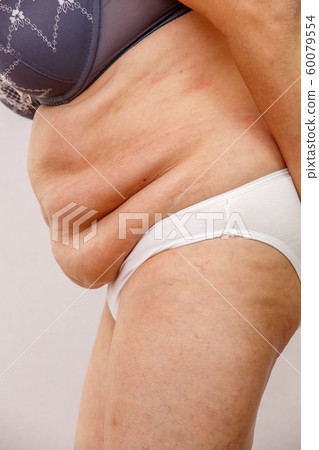 An elderly woman in white panties shows the folds An elderly woman in white panties shows the folds 60079554