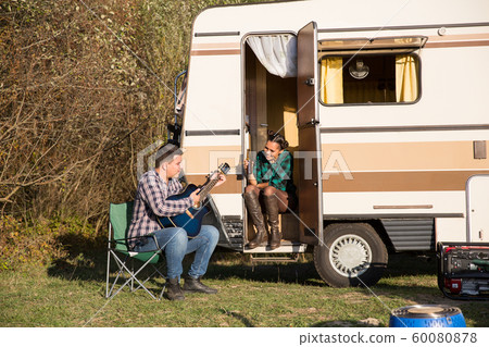 Man trying to play a song on old guitar for his woman Man trying to play a song on old guitar for his woman 60080878