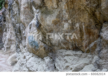 Huge massive natural textured grey-brown stone wall with uneven surface as background or wallpaper. Huge massive natural textured grey-brown stone wall with uneven surface as background or wallpaper. 60082014