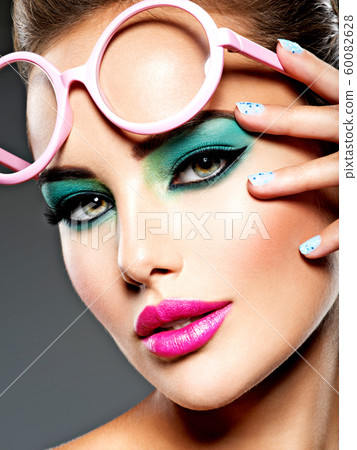 Beautiful Face of a woman with green vivid make-up Beautiful Face of a woman with green vivid make-up 60082628