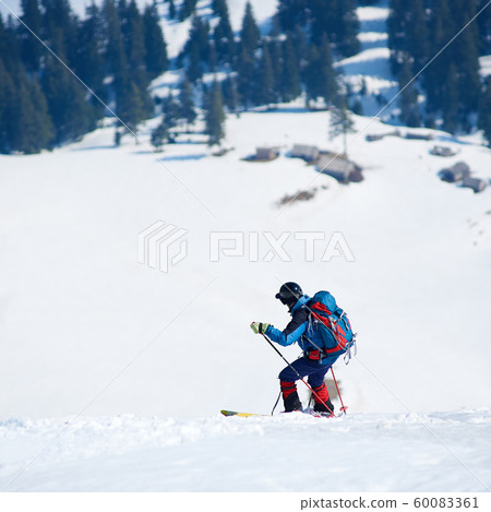 Skier hiker with backpack on skis in deep white snow on background of beautiful winter landscape. Skier hiker with backpack on skis in deep white snow on background of beautiful winter landscape. 60083361