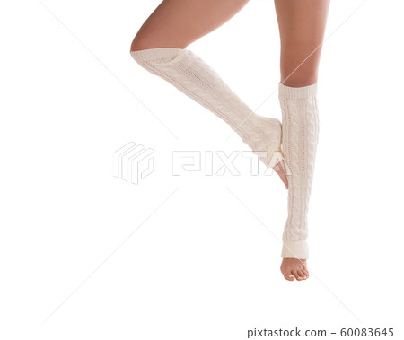 Female slim legs in white leg warmers. Woman stands on tiptoe in dancers position, classic pedicure, isolated. 60083645