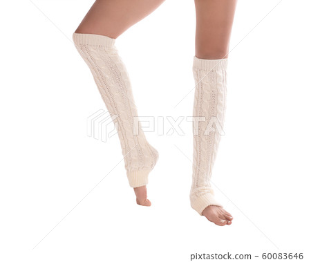 Female slim legs in white leg warmers. Barefooted woman stands in dancers position, classic pedicure, isolated. 60083646