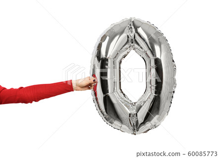 Silvery inflatable figure zero in a female hand. Silvery inflatable figure zero in a female hand. 60085773