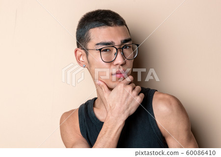 Young sexy man in glasses posing and looking at Young sexy man in glasses posing and looking at 60086410