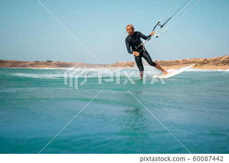 The kite surfer rides the waves of the Atlantic Ocean The kite surfer rides the waves of the Atlantic Ocean 60087442
