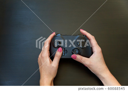 Woman hand holding black joystick isolated on 60088545