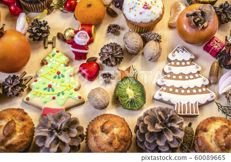 Fruits, Christmas cookies,Santa Claus,nuts,pine cones with chocolate sweets on table Fruits, Christmas cookies,Santa Claus,nuts,pine cones with chocolate sweets on table 60089665
