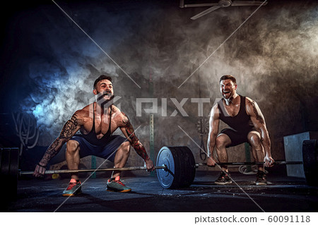 Two muscular bearded tattoed athletes training at gym 60091118