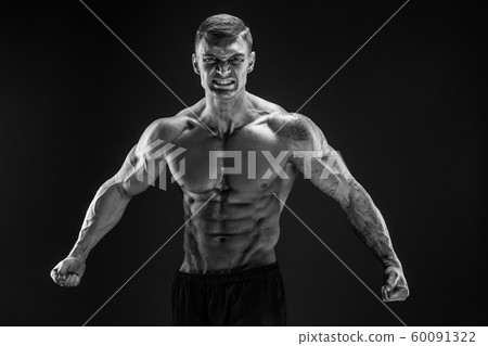 Bodybuilder posing. Fitness muscled man on dark background. Roar Bodybuilder posing. Fitness muscled man on dark background. Roar 60091322