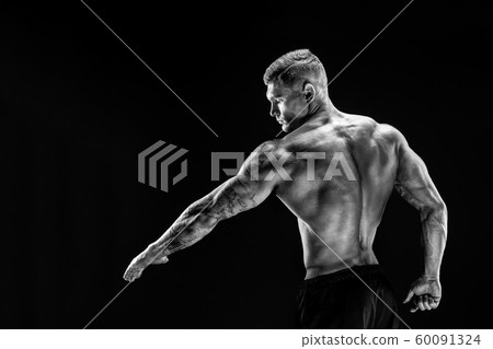 Bodybuilder posing. Fitness muscled man on dark background. Bodybuilder posing. Fitness muscled man on dark background. 60091324