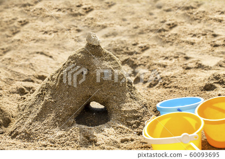 Sandbox, sand pile, sandstone face, light blue and yellow bucket and copy space Sandbox, sand pile, sandstone face, light blue and yellow bucket and copy space 60093695