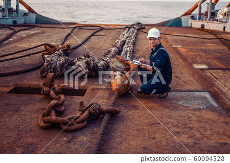 Marine chief officer or chief mate on deck of ship or vessel. He fills up ahts vessel checklist Marine chief officer or chief mate on deck of ship or vessel. He fills up ahts vessel checklist 60094528