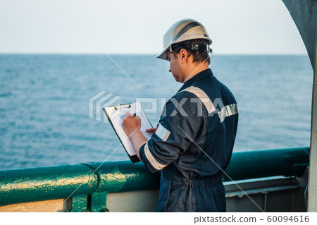 Deck Officer on deck of offshore vessel or ship , wearing PPE personal protective equipment. He 60094616