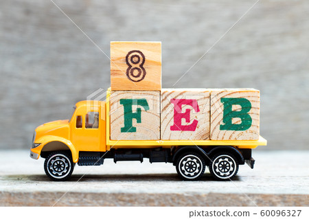 Truck hold letter block in word 8feb on wood background 60096327