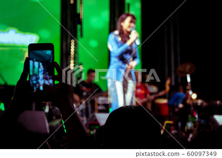 People use mobile phones to live or take pictures People use mobile phones to live or take pictures 60097349