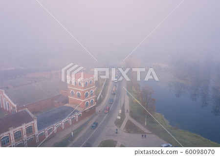 Misty morning in a small town overlooking the road and the old paper mill 60098070