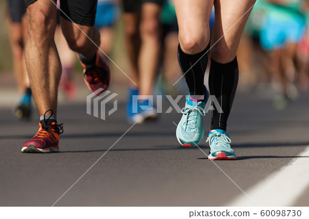 Marathon running race, people feet on city road 60098730