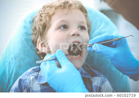 Doctor and patient child. Boy having his teeth examined with dentist. Medicine, health care and stomatology concept Doctor and patient child. Boy having his teeth examined with dentist. Medicine, health care and stomatology concept 60102719