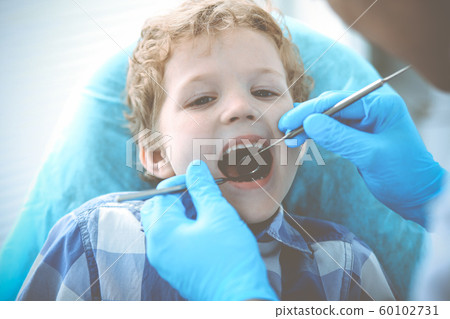Doctor and patient child. Boy having his teeth examined with dentist. Medicine, health care and stomatology concept Doctor and patient child. Boy having his teeth examined with dentist. Medicine, health care and stomatology concept 60102731
