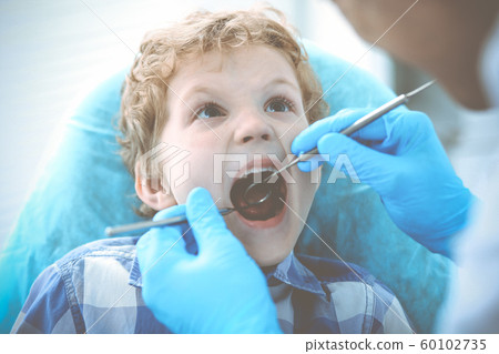 Doctor and patient child. Boy having his teeth examined with dentist. Medicine, health care and stomatology concept Doctor and patient child. Boy having his teeth examined with dentist. Medicine, health care and stomatology concept 60102735