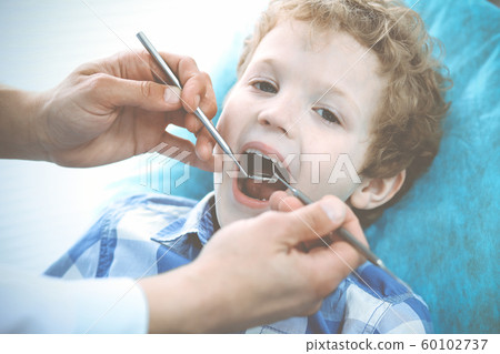 Doctor and patient child. Boy having his teeth examined with dentist. Medicine, health care and stomatology concept 60102737