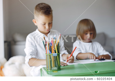 Children siting at the green table and drawing 60105404