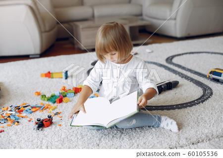 Child playing with book in a playing room 60105536