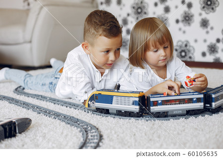 Children playing with lego and toy train in a playing room 60105635