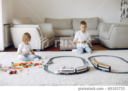 Children playing with lego and toy train in a playing room Children playing with lego and toy train in a playing room 60105735