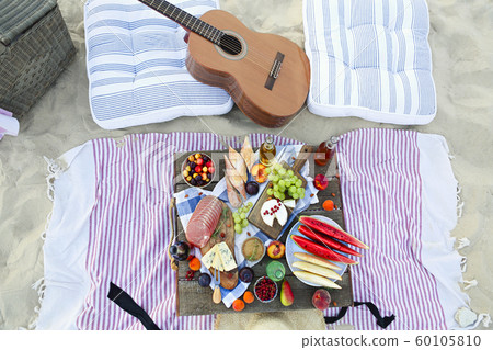 Picnic on the beach at sunset in the style of boho Picnic on the beach at sunset in the style of boho 60105810