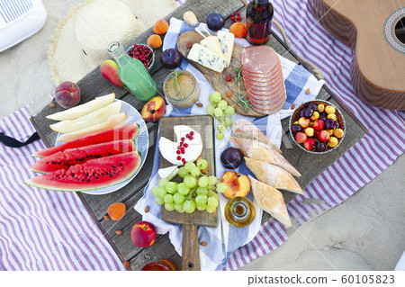 Picnic on the beach at sunset in the style of boho 60105823