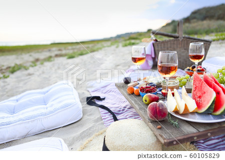 Picnic on the beach at sunset in the style of boho Picnic on the beach at sunset in the style of boho 60105829