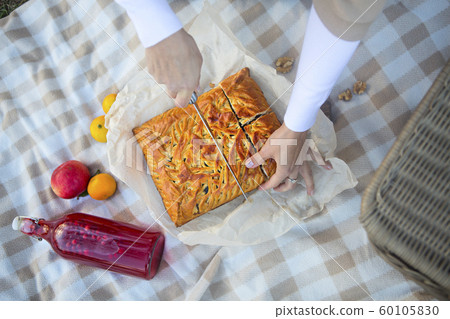 Hands of woman with pieces of apple pie on a Hands of woman with pieces of apple pie on a 60105830