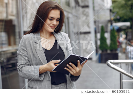 Elegant businesswoman working in a city and use the notebook Elegant businesswoman working in a city and use the notebook 60105951