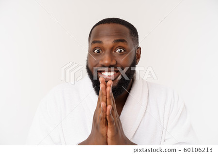 Black guy wearing a bathrobe pointing finger with surprise and happy emotion. Isolated over whtie background. 60106213