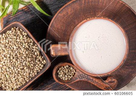 Hemp milk and grains in brown ceramic crockery. Natural superfood concept. Lactose free milk concept. Top view, close-up. 60106605