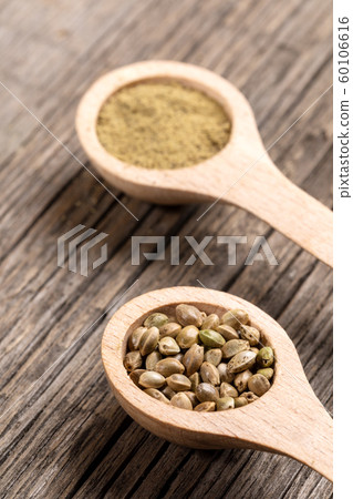 Two wooden spoons with cannabis grains and flour on diagonal old wooden boards. Superfood concept. Selective focus. Two wooden spoons with cannabis grains and flour on diagonal old wooden boards. Superfood concept. Selective focus. 60106616